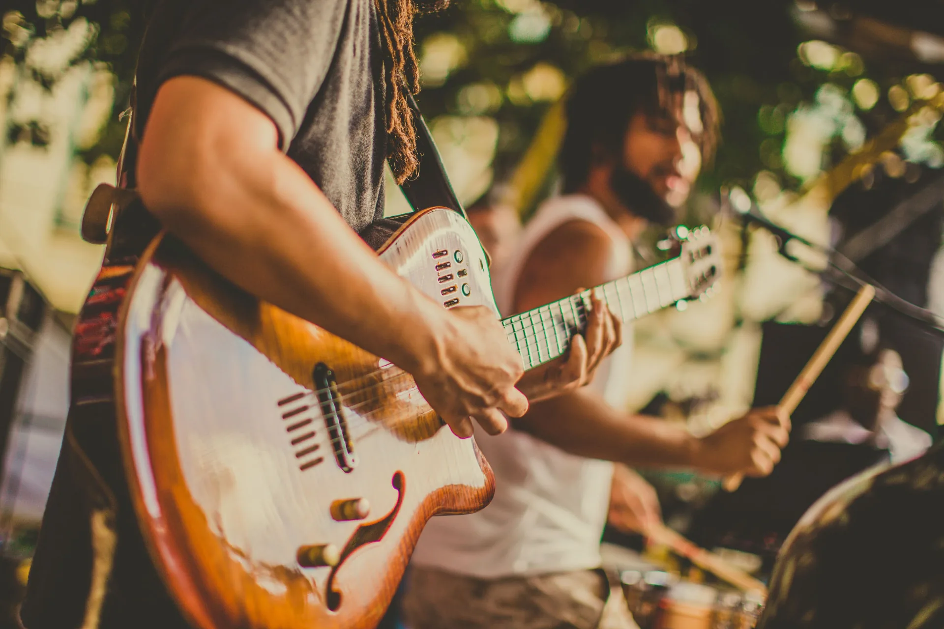 Live band playing outdoors with guitar and drums at MOC27